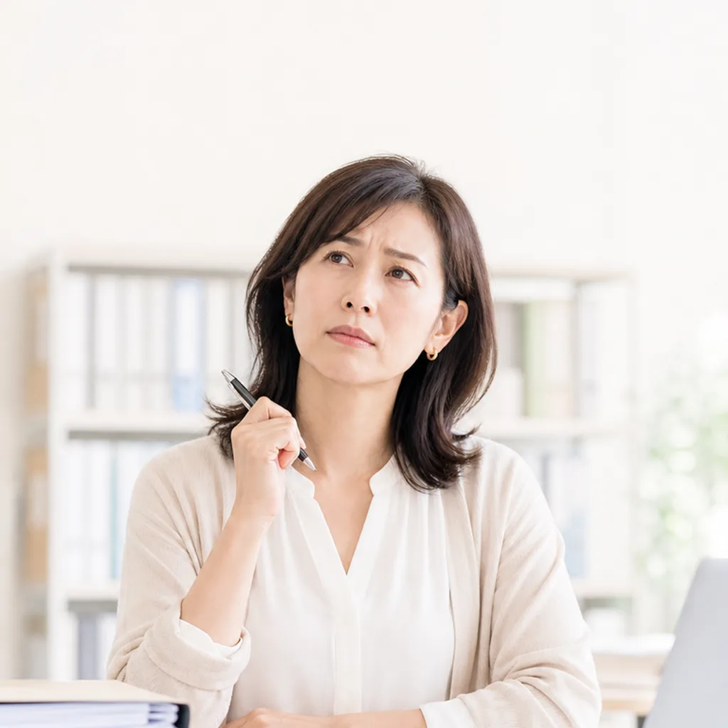 デスクで考え込む管理部門の担当者
